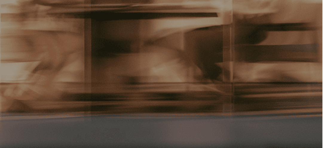 People passing through a glass corridor, motion blurred